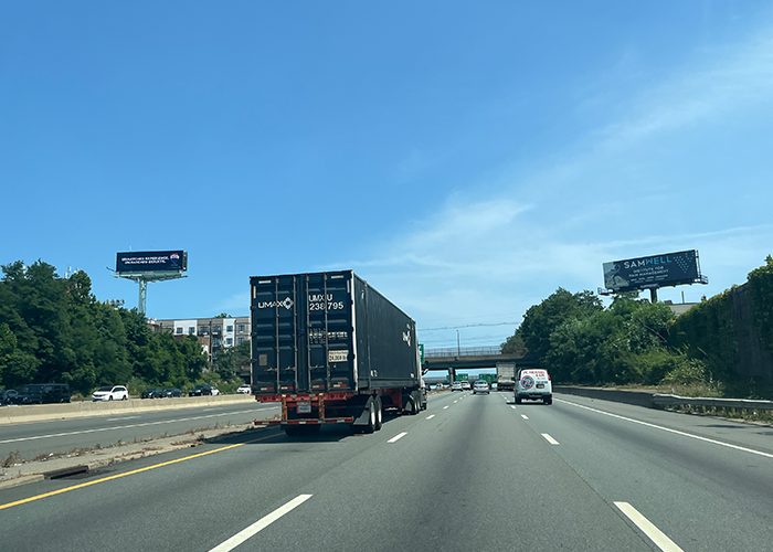 Truck on highway with billboards on both sides